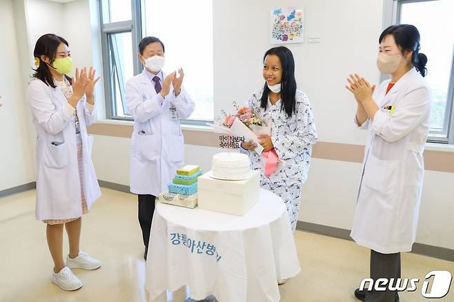 선천성 심장병을 앓고 있는 캄보디아 여성 '마이 찬보파' (가운데)의 무료수술 집도를 한 강릉아산병원 전보배 교수(사진 완쪽)와 소아청소년과 김영휘 교수(왼쪽 두번째) 등이 찬보파 씨의 퇴원을 축하하고 있다.(강릉아산병원 제공) 2022.11.29/뉴스1