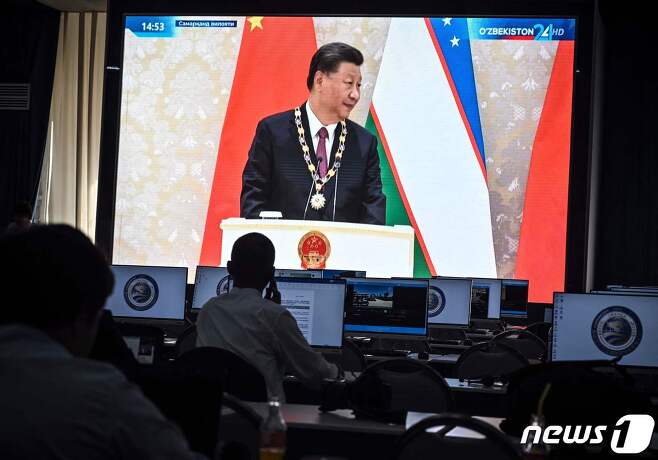 지난 9월 15일 우즈베키스탄 사마르칸트에서 열린 상하이 협력기구(SCO) 정상회의의 프레스센터에 시진핑 중국 국가주석의 영상이 보이고 있다. ⓒ AFP=뉴스1 ⓒ News1 우동명 기자