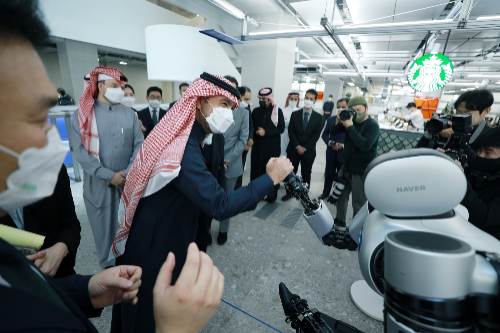 알 호가일 사우디아라비아 자치행정주택부 장관이 네이버1784에서 로봇팔 앰비덱스와 악수하고 있다. [사진=네이버]