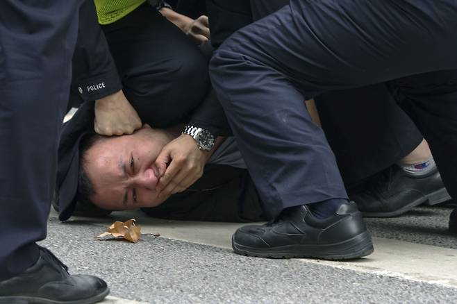 27일 중국 공안이 상하이의 한 거리에서 열린 '제로 코로나' 항의시위 참가자를 제압하고 있다./AP 연합뉴스