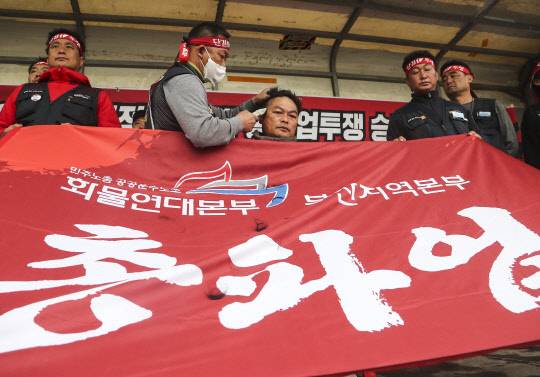 민주노총 산하 화물연대본부 총파업 엿새째인 29일 오후 부산 강서구 부산신항 삼거리에서 부산본부 조합원들이 정부의 업무개시명령에 반발하는 집회를 열고 부산지역본부 송천석 본부장이 삭발하고 있다.<연합뉴스>