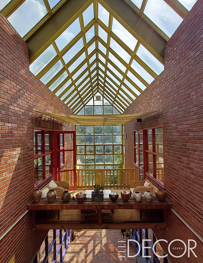 모듈화한 창호로 이루어진 ‘선 룸’이 햇빛을 실내로 가득 들인다. 선 룸을 기준으로 둘로 나뉘어 대칭을 이루는 집. 네 개의 큰 장방형 공간을 기능에 따라 분할, 조립해 구성했다.