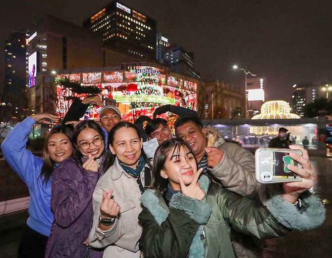 27일 필리핀 단체 관광객 17명은 서울 중구 신세계백화점의 미디어파사드 배경으로 인증샷 찍으며 면세 쇼핑 즐겼다. 이후 자연스럽게 명동 상권을 즐겼다. 신세계면세점 제공.