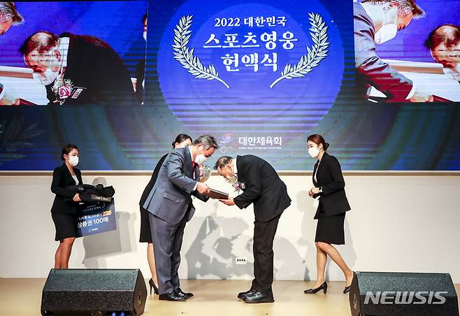 [서울=뉴시스] 정병혁 기자 = 육상인 이봉주가 29일 오후 서울 송파구 올림픽파크텔에서 열린 2022 대한민국 스포츠영웅 헌액식에서 이기흥 대한체육회장에게 헌액패를 전달받고 있다. 2022.11.29. jhope@newsis.com