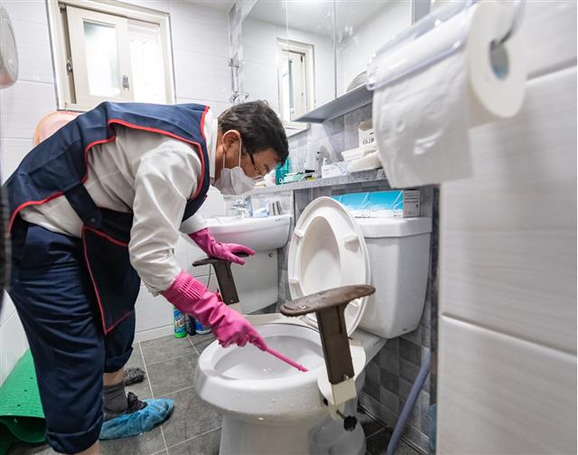 지난달 11일 취약계층 어르신 가정을 방문한 김경호 서울 광진구청장이 직접 화장실 청소를 하고 있다.광진구 제공