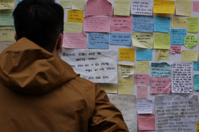 10·29 참사 이후 한 달여가 지난 28일 한 시민이 서울 용산구 이태원동 사고 현장에서 시민들의 추모 글을 읽고 있다. 연합뉴스