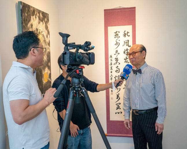 서예가로 변신한 이유생 전 중고태권도연맹 회장이 지난 9월 미국 LA지역 E·K아트갤러리에서 열린 한국서예협회 전시회에서 현지 취재진과 인터뷰하고 있다. 제공 | 삼평장학재단