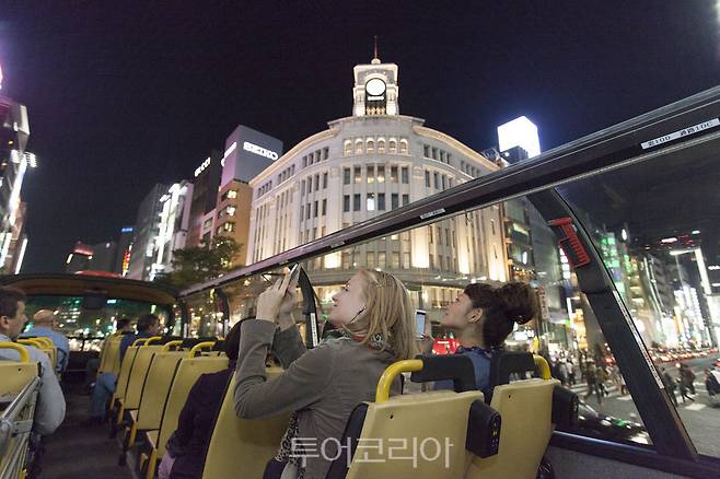 스카이호프 버스에서 도쿄 긴자의 야경을 즐기는 관광객