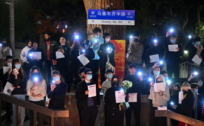 미국 캘리포니아주립대 어바인에서 11월 29일 학생들이 중국 ‘백지 혁명’의 상징인 백지를 들고 중국 정부의 방역 정책 완화를 요구하는 촛불시위를 하고 있다.  AFP 연합뉴스