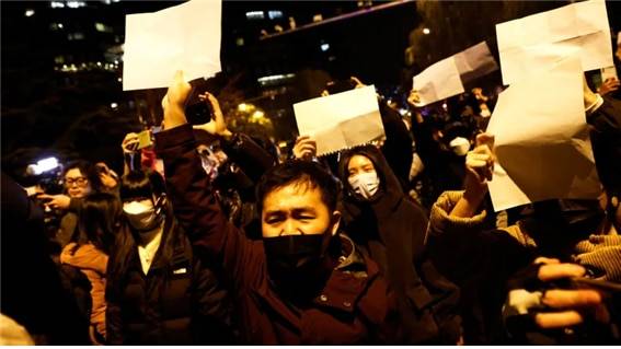 <2022년 11월 27일, 베이징의 시위대가 정부의 검열을 비판하고 표현의 자유를 옹호하는 상징물로 백지를 손에 들고 시위하고 있다. 사진/Thomas Peter/Reuters>