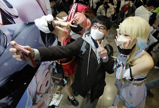 4일 경기도 고양시 킨텍스에서 열린 ‘애니메이션·게임 페스티벌 2022(AGF 2022)’를 찾은 관람객이 원스 코스프레 복장의 관람객과 기념사진을 찍고 있다. (사진=뉴스1)
