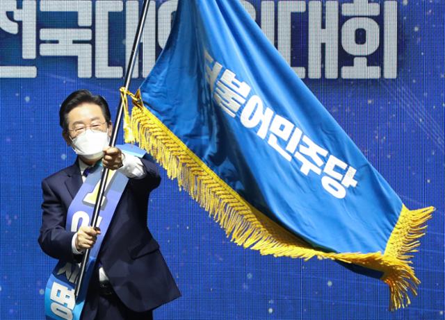 이재명 더불어민주당 당대표가 8월 28일 서울 송파구 올림픽 체조경기장에서 열린 제5차 정기 전국대의원대회에서 당대표로 선출된 뒤 당기를 흔들고 있다. 오대근 기자