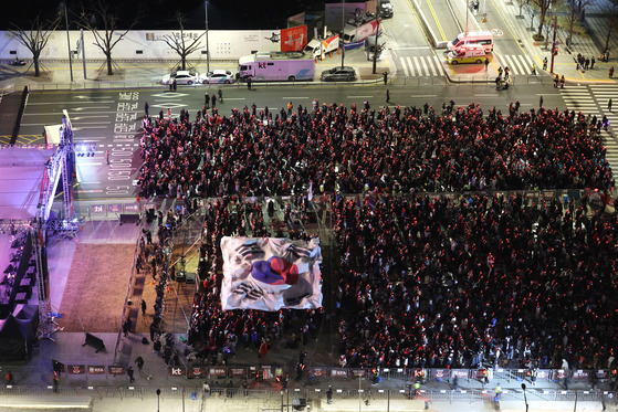 Football fans fill Gwanghwamun Square in central Seoul and hold up the national flag Taegeukgi as they cheer for the Taeguk Warriors in their match against Brazil at the FIFA World Cup in Qatar in the early morning on Tuesday. [YONHAP]