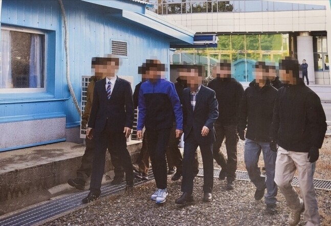 통일부가 12일 언론에 공개한, 2019년 11월7일 판문점에서 ‘동료 살해 북한 어민 2명’을 북송하는 상황을 촬영한 사진. 앞쪽 운동화를 신고 청색과 검정이 섞인 윗옷을 입은 이가 북송된 북한 어민 2명 가운데 한명이다. 통일부 제공