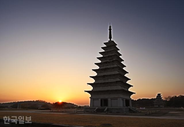 익산 미륵사지 동탑 왼편으로 해가 지고 있다. 1990년대에 복원한 동탑은 매끈하지만 세월이 쌓은 멋이 느껴지지 않는다.