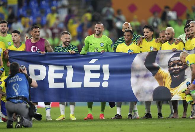 브라질 축구대표팀 선수들이 6일 열린 2022 카타르 월드컵 16강전에서 한국을 꺾은 뒤 암 투병 중인 ‘축구 황제’ 펠레의 회복을 기원하는 플래카드를 펼쳐 보이고 있다. 도하 | 신화연합뉴스
