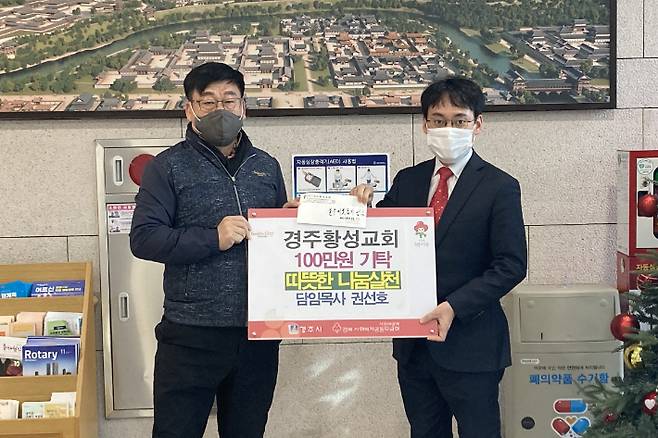 경주황성교회 권선호(우측) 담임목사가 최진열 황성동장에게 성금 100만 원을 전달하고 있다. 경주시 제공