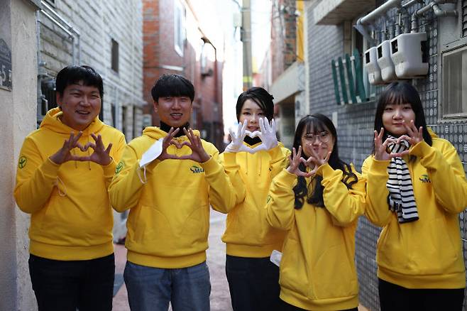 윤석열 대통령 부인 김건희 여사가 8일 부산 부전동 부산진구새마을지회에서 직접 포장한 생필품을 어르신들에게 전달한 뒤 대학생 봉사자들과 기념촬영하고 있다 (사진=대통령실 제공)