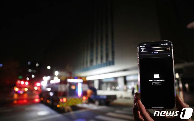 지난 10월15일 오후 경기 성남시 분당구 삼평동 SK판교캠퍼스에서 불이나 소방대원들이 현장을 살피고 있다. 이날 오후 카카오 등 데이터 관리 시설이 입주해있는 이 건물 지하에서 불이나면서 카카오톡, 카카오택시 등 일부서비스에 장애가 빚어지고 있다. 한 휴대폰에 다음 홈페이지 오류 안내가 뜨고 있다. 2022.10.15/뉴스1 ⓒ News1 박세연 기자