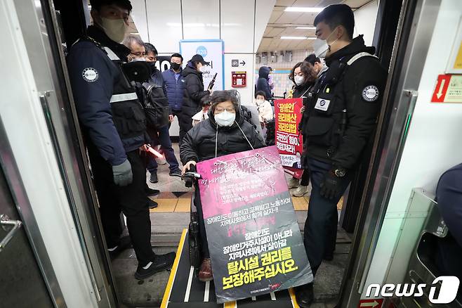 전국장애인차별철폐연대 회원들이 7일 서울 용산구 삼각지역에서 장애인 권리 예산 확보를 위한 지하철 타기 선전전을 위해 치하철에 탑승하고 있다. 2022.12.7/뉴스1 ⓒ News1 조태형 기자