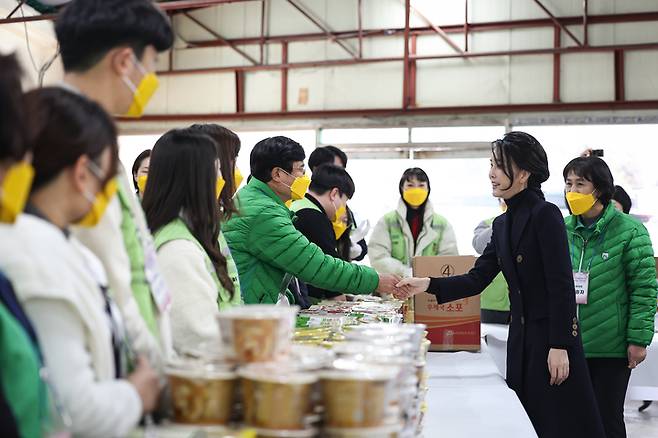 [서울=뉴시스] 윤석열 대통령 부인 김건희 여사가 8일 부산 부전동 부산진구새마을지회에서 쪽방촌 독거노인 등에 전달할 생필품 포장 봉사에 앞서 봉사자들과 인사하고 있다. (사진=대통령실 제공) 2022.12.08. photo@newsis.com *재판매 및 DB 금지