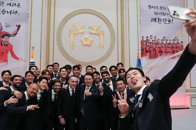 [서울=뉴시스] 윤석열 대통령이 8일 청와대 영빈관에서 열린 카타르 월드컵 축구 국가대표팀 환영 만찬에서 파울로 벤투 감독 및 선수단, 코치진 등 참석자들과 셀카를 찍고 있다. (사진=대통령실 제공) 2022.12.08. photo@newsis.com *재판매 및 DB 금지