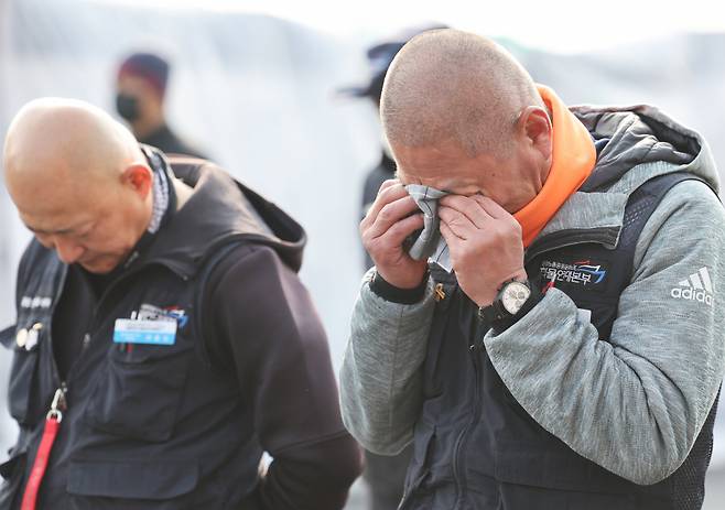 화물연대가 파업을 종료하고 현장 복귀를 결정한 12월9일 경기도 의왕시 내륙컨테이너기지(ICD)에서 조합원들이 눈물을 닦고 있다. ⓒ 연합뉴스