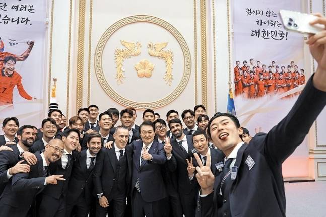 윤석열 대통령이 지난 8일 청와대 영빈관에서 카타르 월드컵 축구 국가대표팀을 초청해 환영 만찬을 가졌다. 조규성 선수(맨 앞)가 자신의 휴대전화로 단체 셀프카메라를 찍고 있다. 대통령실 제공