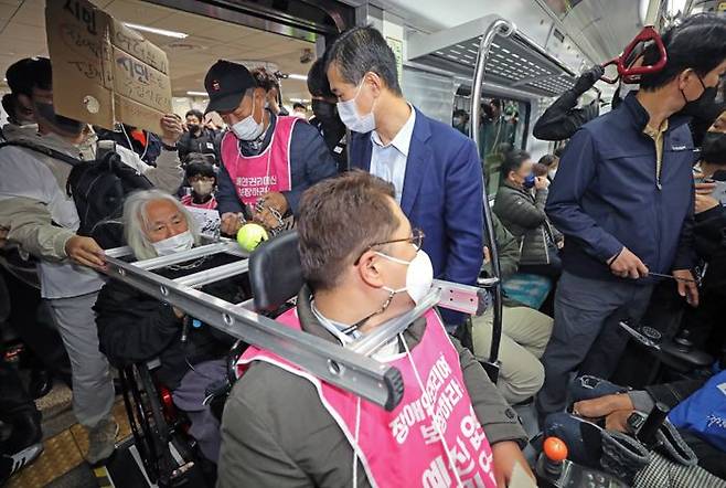 전국장애인차별철폐연대 활동가들이 지난 10월 서울 서초구 교대역 2호선 승강장에서 '출근길 지하철 탑니다' 시위를 하고 있다. ⓒ뉴시스