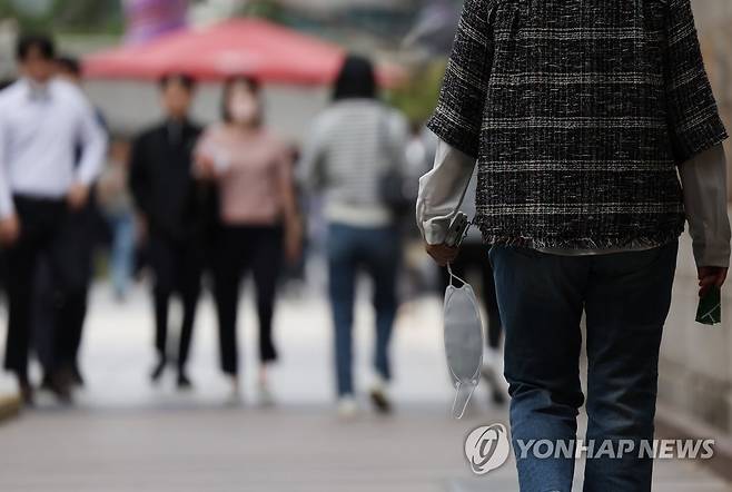 실외 마스크 착용 의무 해제 (서울=연합뉴스) 신준희 기자 = 실외 마스크 착용 의무가 전면 해제된 9월 26일 서울 청계천에서 마스크를 벗고 걸어가는 직장인. hama@yna.co.kr