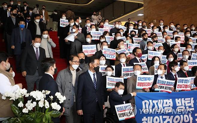 이상민 해임 건의안 처리 규탄하는 국민의힘 의원들과 표결 마친 민주당 의원들 (서울=연합뉴스) 하사헌 기자 = 국민의힘 의원들이 11일 국회 로텐더홀 계단에서 이상민 행정안전부 장관 해임 건의안 강행 처리를 규탄하는 피켓을 들고 있는 가운데 본회의 표결을 마친 더불어민주당 의원들이 계단을 내려오고 있다. 2022.12.11 [공동취재] toadboy@yna.co.kr