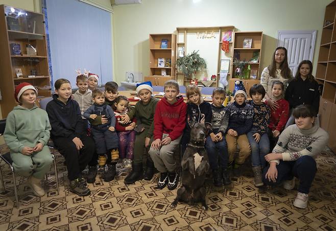 지난 7일 우크라이나 키이우 인근 도시 보야카의 한 심리치료센터에서 심리치료견 ‘바이스’와 사진을 찍고 있는 아이들. AP 연합뉴스