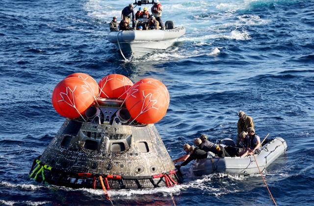 미 해군 소속 잠수부들이 11일 멕시코 바하칼리포르니아주 인근 해안에 착륙한 아르테미스 1호 우주선 오리온에 접근하고 있다. 로이터 연합뉴스