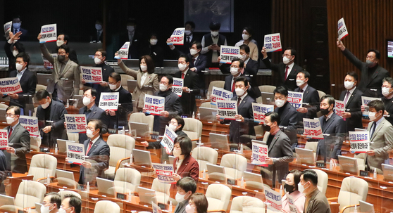 Lawmakers from the People Power Party (PPP) hold up placards to protest the Democratic Party's no-confidence motion against Interior Minister Lee Sang-min at the National Assembly in Yeouido, western Seoul on Sunday. [NEWS1]