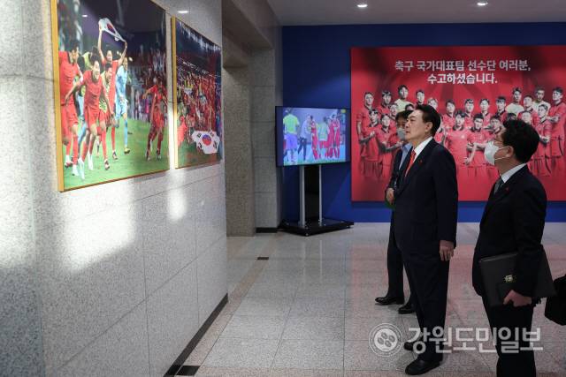 ▲ 윤석열 대통령이 13일 용산 대통령실 1층 로비에 전시된 월드컵 16강 진출 기념사진을 둘러보고 있다. 사진/대통령실 제공