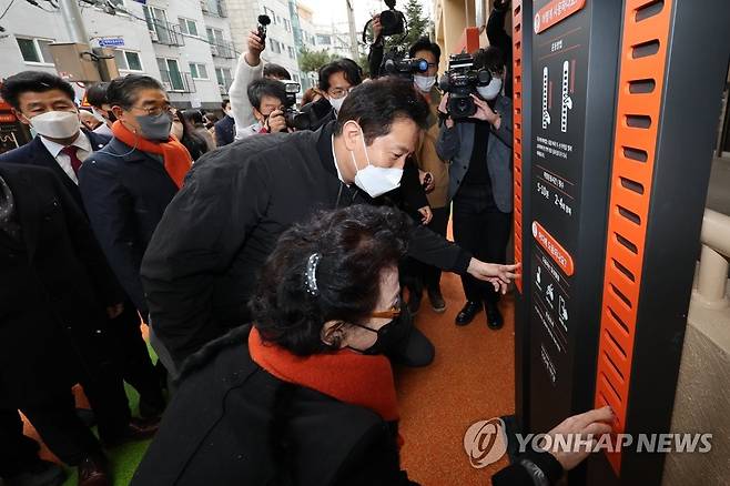 '100세 마당' 찾은 오세훈 시장 (서울=연합뉴스) 김주성 기자 = 오세훈 서울시장이 13일 오후 서울 송파노인종합복지관에 설치된 '100세 마당'을 방문, 한 노인과 손가락 운동 프로그램을 체험하고 있다. 
    '100세 마당'은 노인복지관 앞마당이나 동네공원 같은 생활권 안에 운동기구와 인지건강 프로그램 등을 함께 배치한 고령층 건강을 위한 공간이다. 2022.12.13 utzza@yna.co.kr