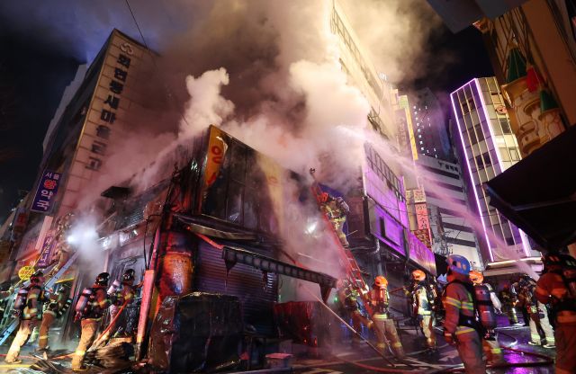 소방관들이 14일 밤 서울 중구 남대문시장 인근 건물 주변에서 불길을 잡고 있다. 연합뉴스