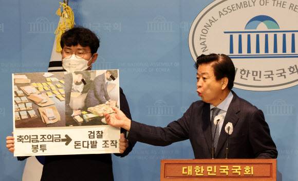 뇌물과 불법 정치자금 수수 혐의로 사전 구속영장이 청구된 노웅래 더불어민주당 의원이 14일 국회 소통관에서 기자회견을 열고 “검찰이 축조의금 봉투 돈까지 꺼내 돈다발로 조작했다”고 주장하고 있다.연합뉴스