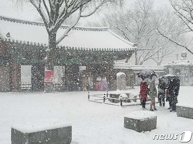 17일 눈이 내리는 전북 전주한옥마을. 경기전 입구에서 관광객들이 겨울 정취를 만끽하고 있다.2022.12.17/뉴스1 ⓒ News1 강교현기자