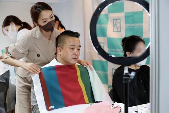 A man finds his personal color with a consultant at a job fair held in Yongin, Gyeonggi, on June 15. [NEWS1]