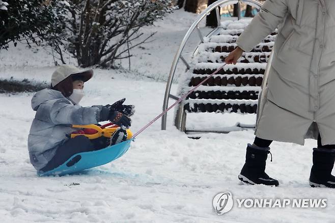 눈썰매 '씽씽' (광주=연합뉴스) 차지욱 기자 = 대설주의보가 내려진 17일 오후 광주 서구 상무 근린공원에서 한 아이가 눈썰매를 타고 있다. 2022.12.17 uk@yna.co.kr