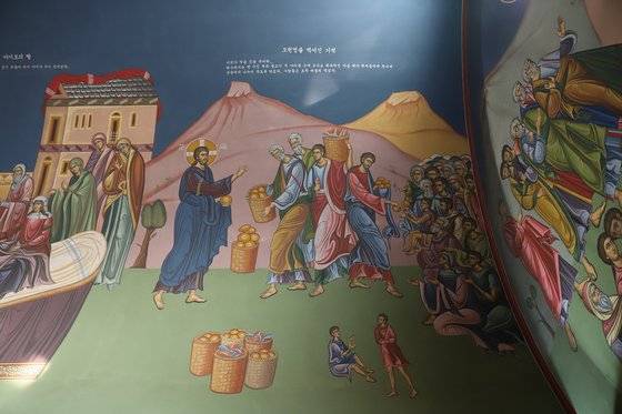 울산 성 디오니시오스 성당 내부에 새겨진 성화. 예수가 물고기 두 마리와 떡 다섯 개로 5000명을 먹인 기적이 그려져 있다. 최승표 기자