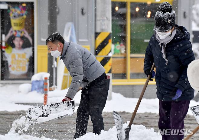 [광주=뉴시스] 이영주 기자 = 광주 지역에 대설 특보가 내려진 18일 오전 광주 동구 한 인도에서 계림2동행정복지센터 직원들이 제설 작업을 하고 있다. 2022.12.18. leeyj2578@newsis.com