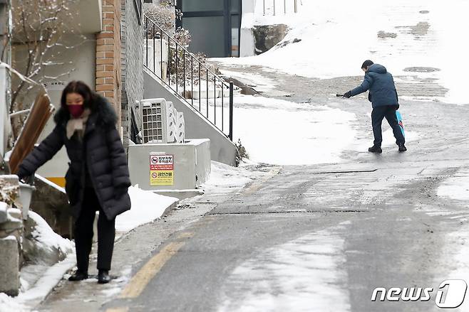 서울 마포구 인근에서 시민이 집 앞에 쌓인 눈을 치우고 있다. 2022.12.21/뉴스1 ⓒ News1 김민지 기자