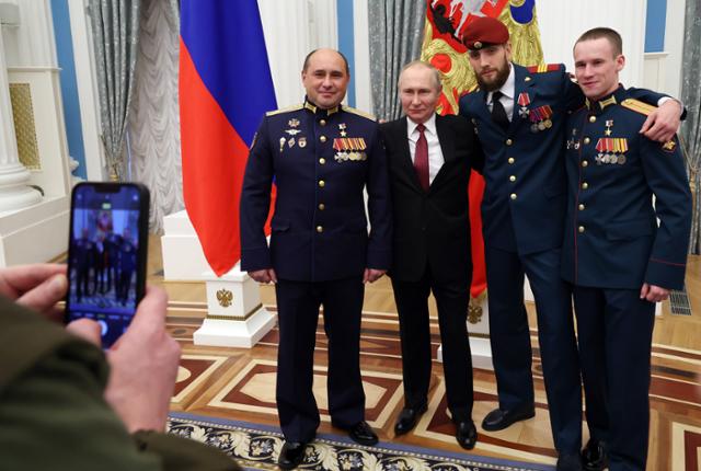 블라디미르 푸틴(왼쪽에서 두 번째) 러시아 대통령이 20일 모스크바 크렘린궁에서 우크라이나 전쟁 유공자들에게 훈장을 수여한 뒤 기념촬영을 하고 있다. 모스크바=EPA 연합뉴스