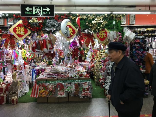 중국의 한 노인이 지난 2017년 12월 상하이의 크리스마스 장식을 판매하는 상점 앞을 지나고 있다. 게티이미지