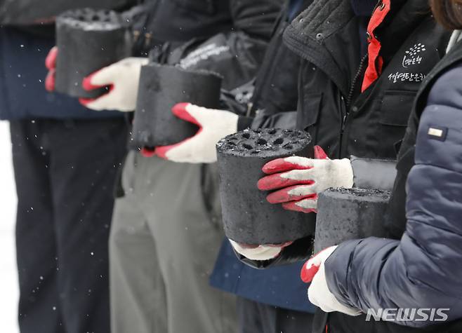 [서울=뉴시스] 고승민 기자 = 정진석 국민의힘 비상대책위원장과 당직자들이 21일 서울 구룡마을에서 연탄나눔 봉사를 하고 있다. 2022.12.21. kkssmm99@newsis.com