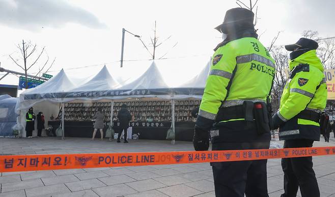 Police officers stand in front of a police line at a mourning altar for Itaewon crown crush victims in Seoul, Thursday. (Yonhap)