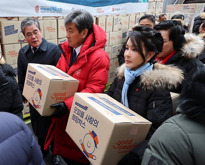 김건희 여사가 22일 서울 남대문 쪽방촌에서 열린 '이웃과 함께하는 2022 찾아가는 성탄절, 희망박스 나눔행사'에서 쪽방촌 주민들에게 식료품 등이 담긴 '희망박스'를 전달하기 위해 이동하고 있다. [연합]