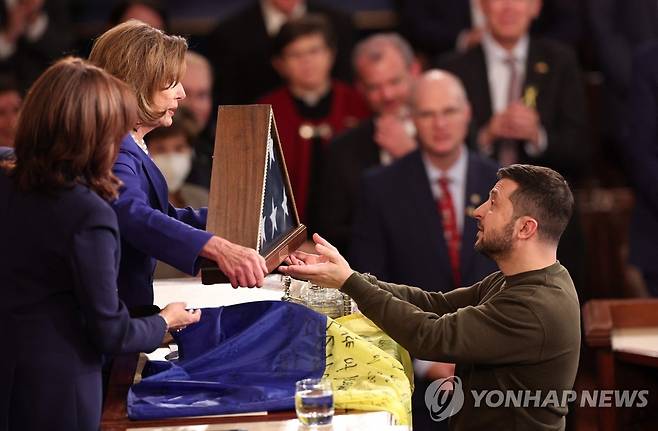 젤렌스키 우크라 대통령 美의회 연설 (워싱턴 AFP=연합뉴스) 낸시 펠로시 미국 하원의장이 21일(현지시간) 워싱턴DC에 있는 미 의회에서 연설한 볼로디미르 젤레스키 우크라이나 대통령에게 성조기를 전달하고 있다. 2022.12.21